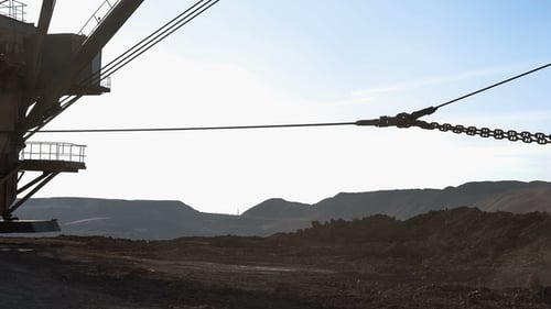 Dragline-Bagger lädt Erz. Das Erz wird aus dem Eimer gegossen.