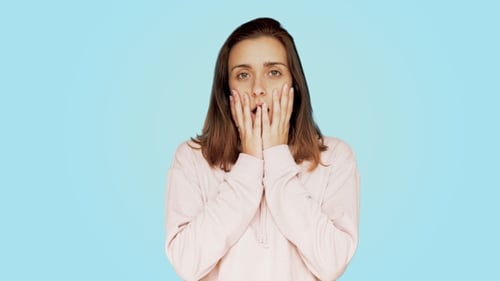 Woman Reacts with Shock and Covers Her Mouth