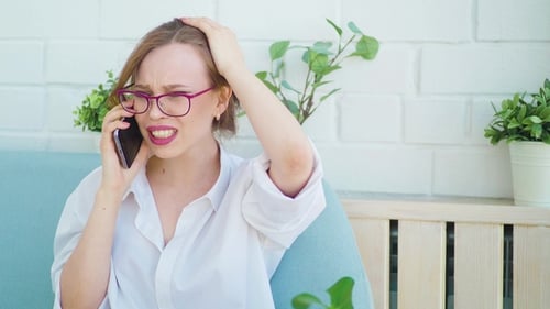 Angry Woman Arguing on the Phone Indoors
