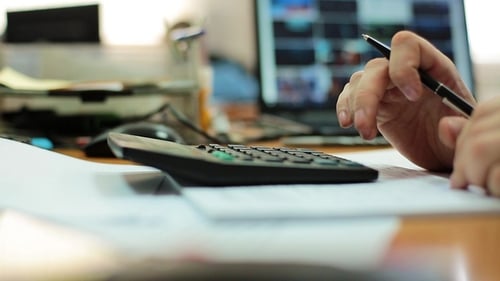 A Male Hand Using Calculator in the Office