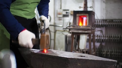 Blacksmith Shaping Red Hot Metal with Hammer