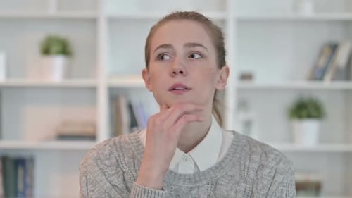 Woman Ponders, Thinking in Front of Bookshelf