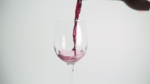 Red Wine Pouring into Clear Glass