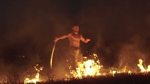 Entraînement de combattant libre avec l'épée dans le champ de la nuit ardente. Lentement