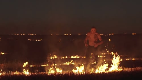 Entraînement de combattant libre avec l'épée dans le champ de la nuit ardente. Lentement