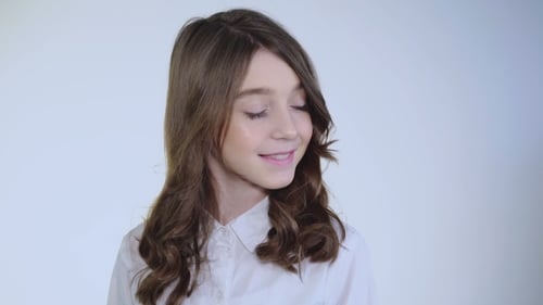 Teen Girl Smiles and Plays With Hair