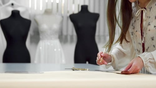 Fashion Designer Measuring Fabric in Bright Studio