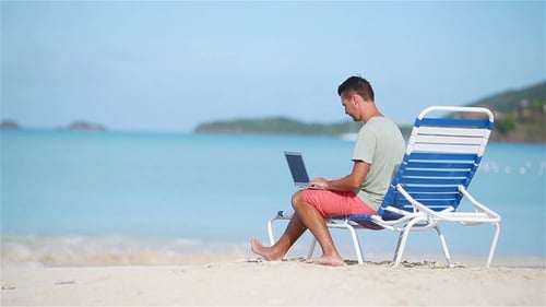 Joven con tablet PC durante vacaciones en la playa tropical