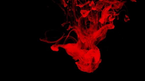Red Ink Swirling in Water on Black