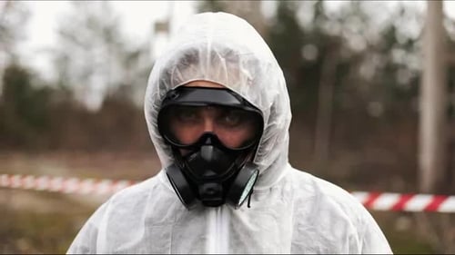 Person in Hazmat Suit and Respirator Outdoors
