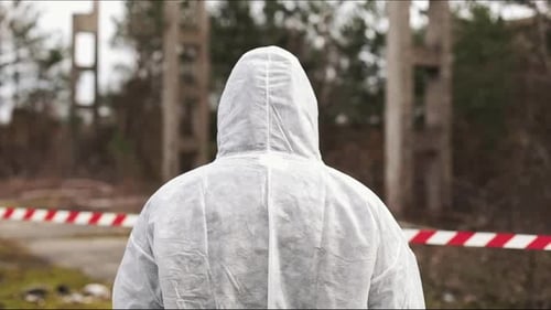 Hazmat Suited Person Walks Through Post Apocalyptic Landscape