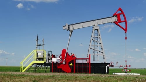 Rural Oil Pump Jack Working Under Blue Sky