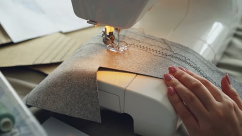 Woman Sewing Fabric with a Sewing Machine