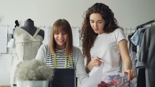 Fashion Designers Collaborating on Designs in Studio