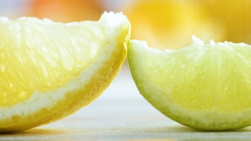 Footage of Rain Falling on Lemon, Lime and Orange Slices on White Wooden Table