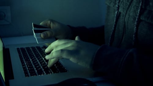 Imagens de um hacker segurando Código de digitação de cartões de crédito no laptop. Homem usando computador à noite. Perfeito