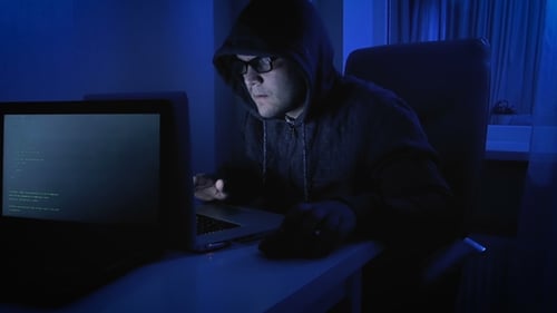 Funny Footage of Male Pretends To Be Hacker. Geeky Man in Hood Working on Laptop at Night
