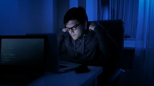 Young Adult Working on a Laptop at Night