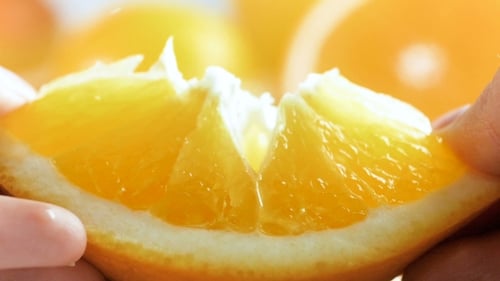 Hands Separate Segment of a Slice of Orange