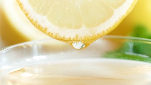 Squeezing Lemon Juice into a Glass of Drink