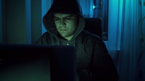 Hooded Male Coding at Computer at Night