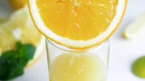 Vidéo de jus frais coulant d'une tranche d'orange dans un verre