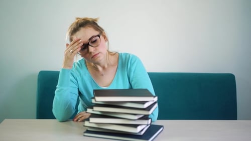 Tired, Angry, Exhausted Student Lowered Her Head on a Stack of Books