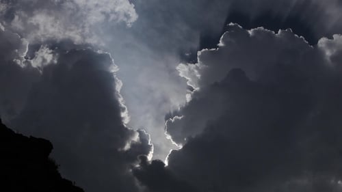Sunlight Streams Through Dark Clouds in Dramatic Sky
