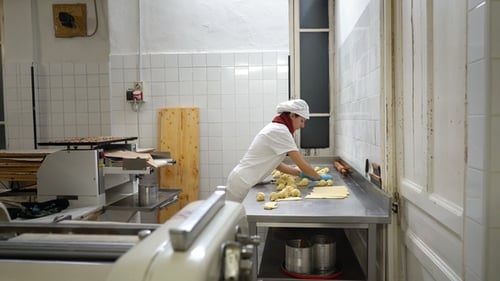 Traditional Italian Bakery. A Female Baker Turns Beautiful Croissants Before Baking