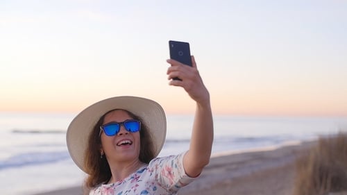 Young Woman Tourist Making Portrait Photo on a Beach