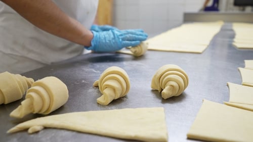 Baker Shaping Croissants at a Commercial Bakery