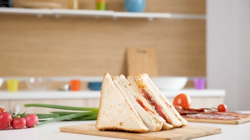 Four Club Sandwiches Lying on Wooden Board