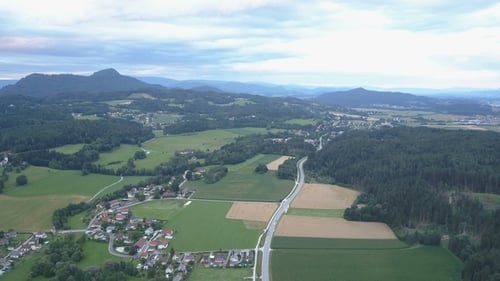 Cars Moving on a Road Near a Village