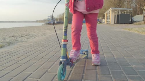 Fille sur un scooter pour enfants