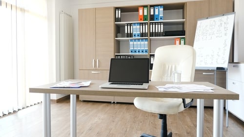 A Modern Laptop on a Desk in the Middle of Modern Empty Office