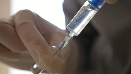 Syringe Sucks in Some Medical Liquid From a Glass Ampule in a Hospital Room