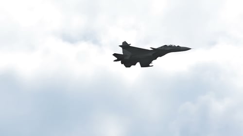 Airplane Silhouette Flying Against Cloudy Sky