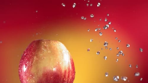 Fliegen von Red Apple auf rot-gelbem Hintergrund in Zeitlupe
