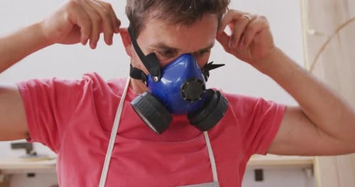 Adult Puts on Protective Blue Respirator Mask