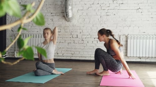 Yoga Instructor Helping Student in Studio