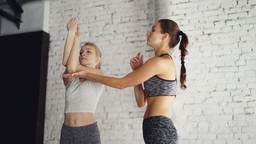 Women Stretch Arms in Gym Studio