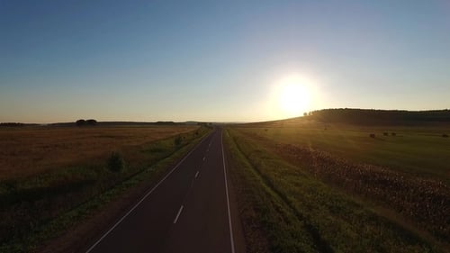 Aerial View Above Asphalt Road in the Field on the Sunset