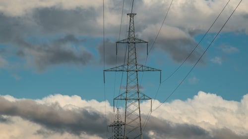 High Voltage Electricity Tower Pylons and Transmission Power Lines on the Cloudy Sky Background.