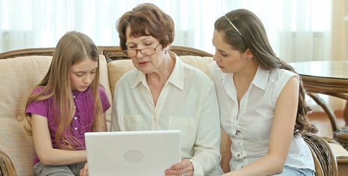 Three Generations Using Laptop Together at Home