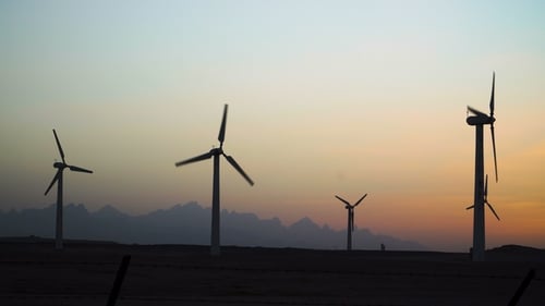 Beautiful Windmill Turbines Harnessing Clean, Green, Wind Energy Silhouetted in the Sunset Sky with