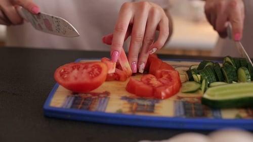 Hands cutting vegetables on a cutting board