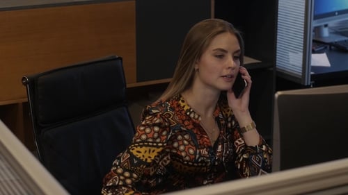 Young Woman Answering Phone at Desk in Office