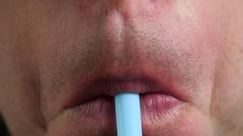 Close Up of Man Drinking from Straw