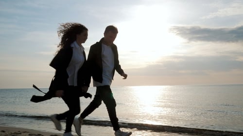 Young Couple Running on the Sandy Beach. Pair Having Fun, Fooling, Holding Hands, Enjoying Moment