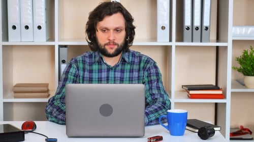Man Working at Laptop Gives Thumbs Up